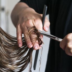 Friseur schneidet langes Haar